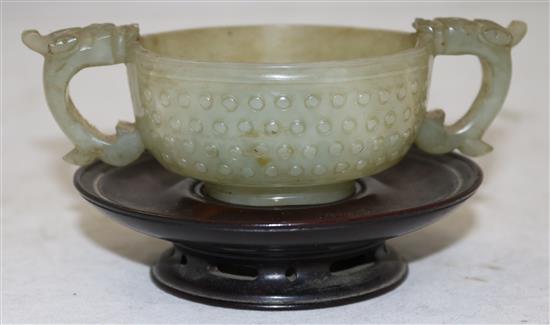 A Chinese celadon jade two handled cup, 17th century, width 12.5cm, rosewood stand